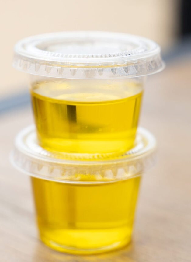 two-plastic-containers-with-olive-oil-individual-serving-portion-pandemic-restaurant-protocols